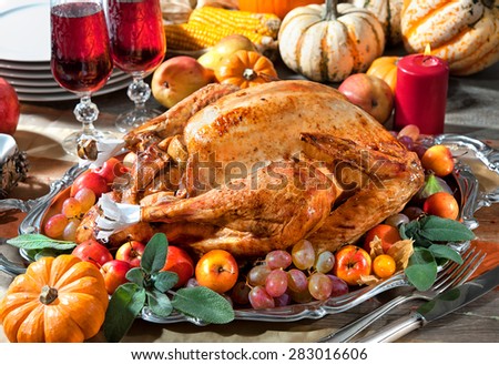 Thanksgiving dinner. Roasted turkey on holiday table with pumpkins, flowers and wine
