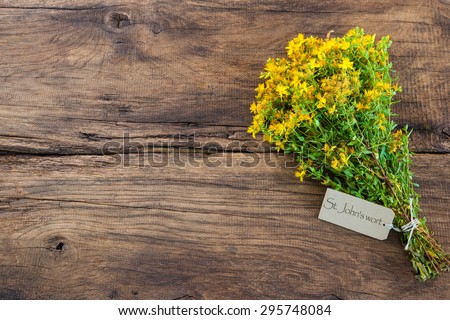 Hypericum perforatum or St john\'s wort with a tag on wooden background
