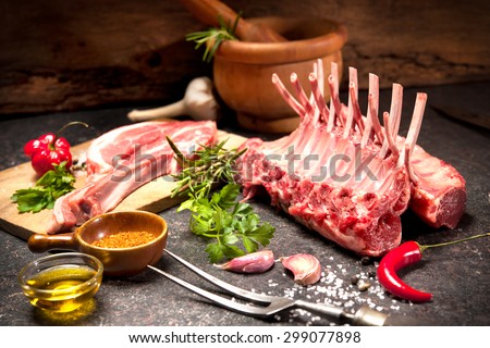 Racks of lamb ready for cooking on dark background