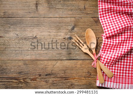 Kitchenware on wooden table with a red checkered tablecloth