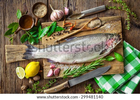Fresh trout with spices and seasoning on cutting board