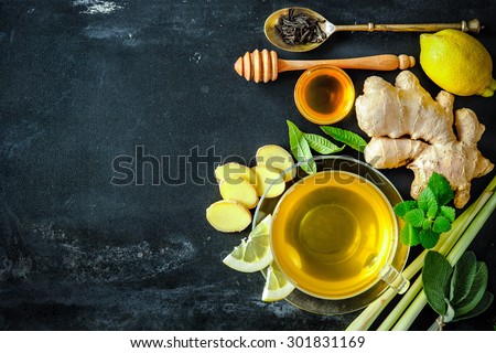 Cup of ginger tea with lemon and honey on slate plate