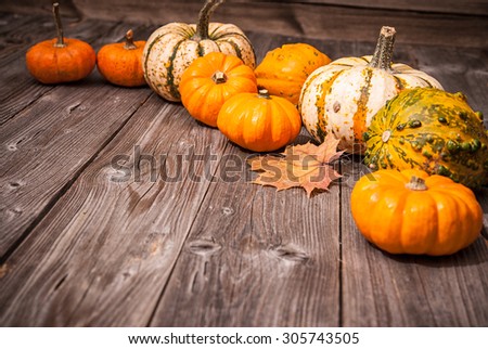 Autumn still life with pumpkins and leaves on old wooden background