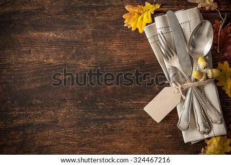 Thanksgiving autumn place setting with cutlery and arrangement of colorful fall leaves