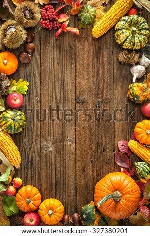 Harvest or Thanksgiving background with autumnal fruits and gourds on a rustic wooden table