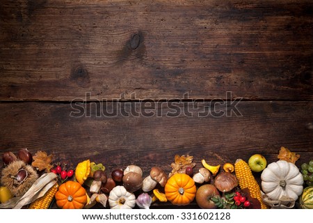 Harvest or Thanksgiving background with autumnal fruits and gourds on a rustic wooden table