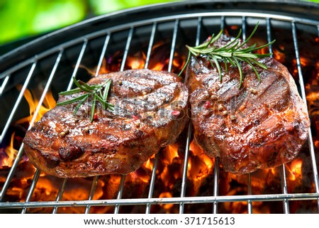 Grilled beef steaks over the coals on a barbecue grill