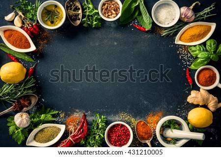 Herbs and spices over black stone background. Top view with copy space