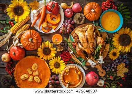 Thanksgiving dinner. Roasted turkey with pumpkins and sunflowers on wooden table