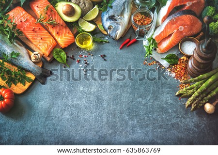 Assortment of fresh fish with aromatic herbs, spices and vegetables. Balanced diet or cooking concept