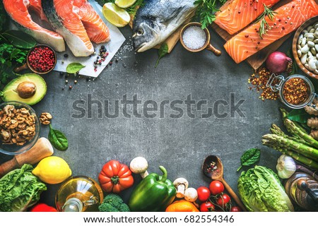Assortment of fresh fish with aromatic herbs, spices and vegetables. Balanced diet or cooking concept