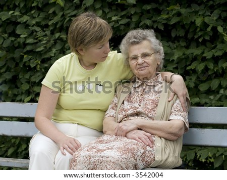 elderly woman with her daughter on the the park bench