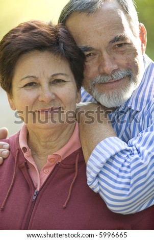 Happy elderly couple embracing outdoors