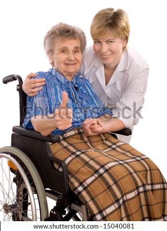 Health care worker and elderly woman in wheelchair giving thumbs-up sign