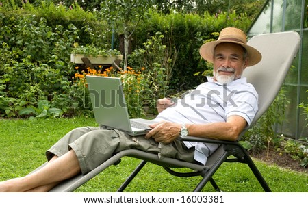 senior  in garden at leisure with laptop computer