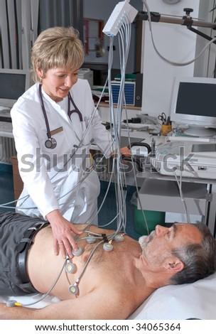 doctor makes the elderly patient ready for  EKG test
