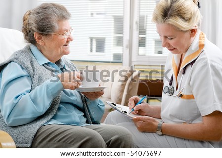 Senior woman is visited by her doctor or caregiver at home
