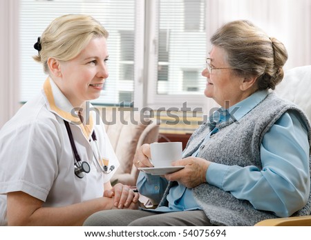 Senior woman is visited by her doctor or caregiver at home