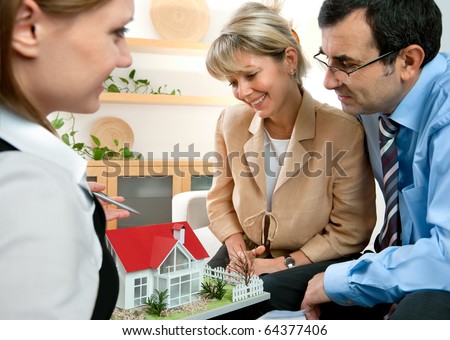 mid-adult couple discussing  with consultant, real estate agent or architect