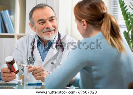 A doctor prescribes a medicine  to a young patient during visit in the office.