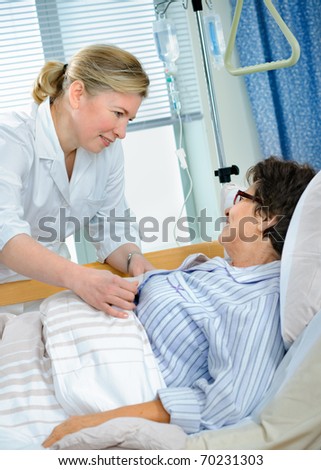 Nurse cares for a senior patient lying in bed in hospital