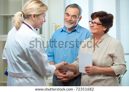 doctor handshaking with a senior couple