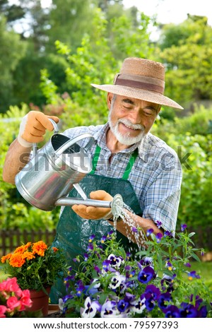 Portrait of senior man watering flowers