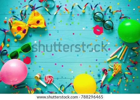 Colorful birthday or carnival frame with party items on wooden background