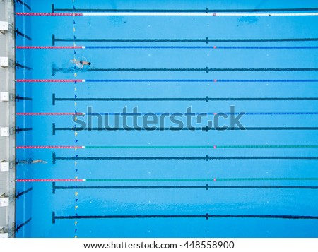 Bird Eye View of Blue Swimming Pool with Swimmers and Starting Platform.