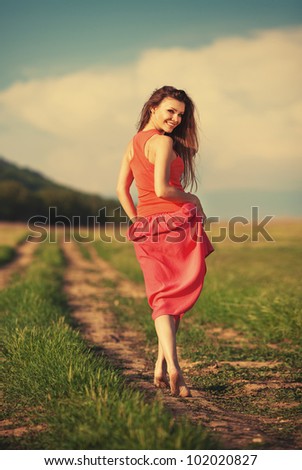 Portrait of young attractive smiling woman walking on the road outdoor in summer