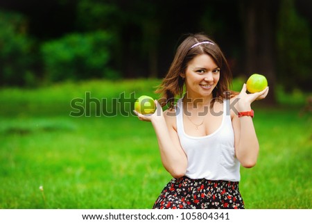 portrait long-haired woman hands red apple background summer park