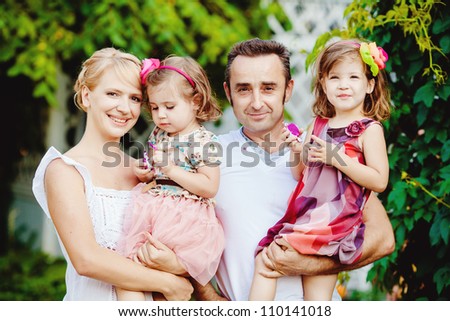 Happy family having fun outdoors in spring park against natural green background