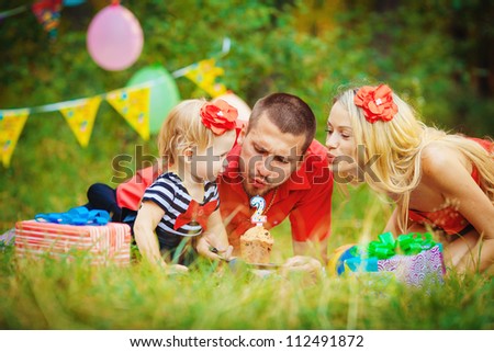 Family celebrating birthday party in green park outdoors