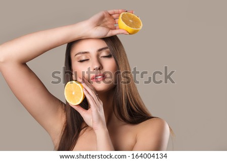 Close up portrait of young emotional beautiful woman with lemon in her hands. Perfect skin! Isolated