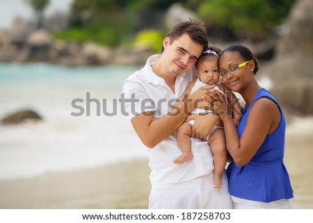 Family beach vacation. Smiling happy parents with kids having fun on beach near sea