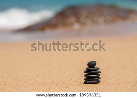 zen black stones laying on the beach near the water of ocean. Outdoors. Beach on the background