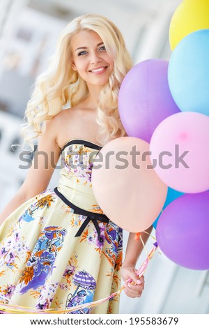 summer holidays, celebration and lifestyle concept - beautiful blonde woman with colorful balloons in the city. Bright summer portrait