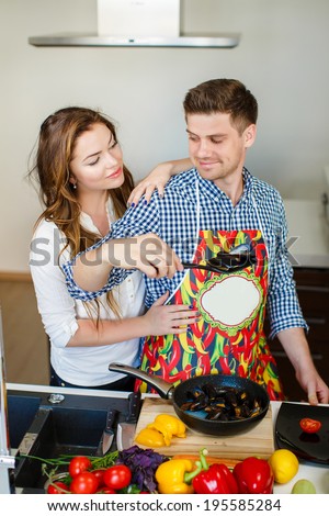 Married couple enjoying their time at home cooking. Man coocking. Husband and wife in the kitchen at home