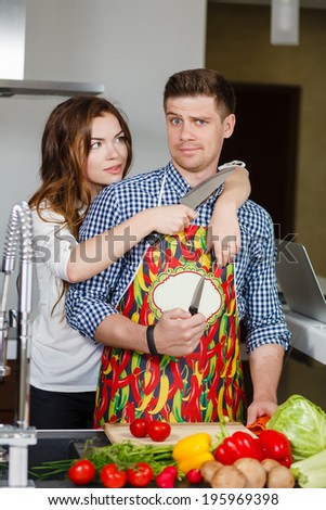 Happy Couple Cooking Together - Man and Woman in their Kitchen at home Preparing Vegetable Salad.Diet.Dieting. Healthy Food