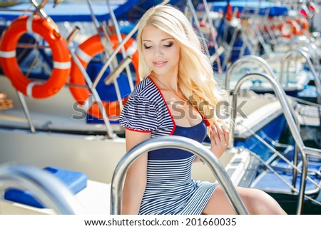 Adorable woman wearing sea Captain\'s cap and sexy sailor T-shirt. Attractive woman on a yacht on summer day