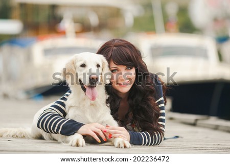 Beautiful girl with her dog near sea. Portrait of young girl with her dog.