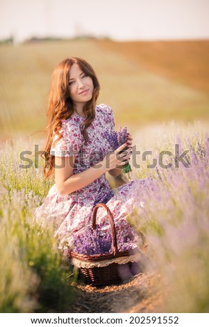 Beautiful sexy caucasian woman sitting on the grass on summer meadow. Portrait of the young beautiful smiling woman outdoors.