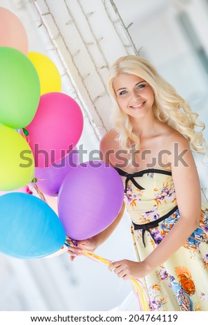 summer holidays, celebration and lifestyle concept - beautiful woman with colorful balloons in the city. Happy young woman with colorful latex balloons keeping her dress, urban scene, outdoors