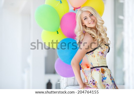 summer holidays, celebration and lifestyle concept - beautiful woman with colorful balloons in the city. Happy young woman with colorful latex balloons keeping her dress, urban scene, outdoors