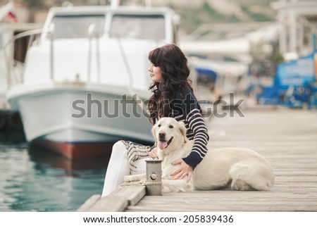 Portrait of beautiful young woman playing with dog on the sea shore. Beautiful girl playing with a dog. Outdoor portrait. series