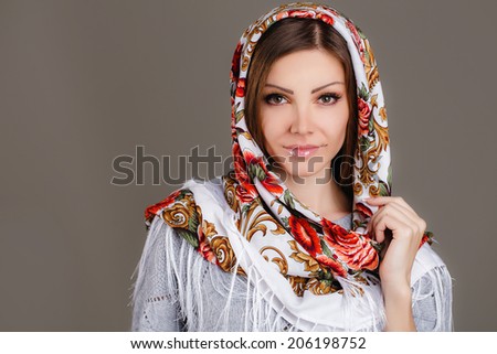 beautiful oriental look. portrait of a beautiful young woman with a scarf on her head. Russian beauty. Russian national traditional scarf on head.