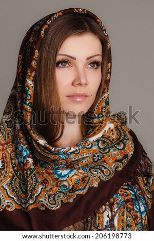 portrait of a beautiful young woman with a scarf on her head. Russian beauty. Russian national traditional scarf on head.