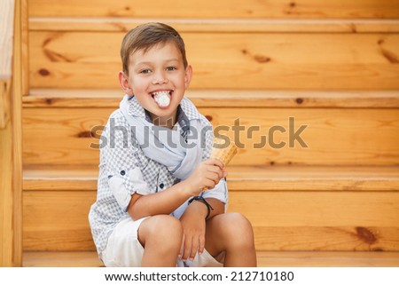 kid eating ice cream ioutdoor. happy child boy eating ice cream