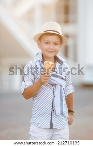 kid eating ice cream ioutdoor. happy child boy eating ice cream