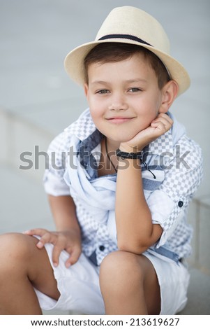 stylish baby boy having fun outside in the park. Cute happy boy child outdoors. cute little stylish boy in classic style in the city. Happy child posing outdoor.